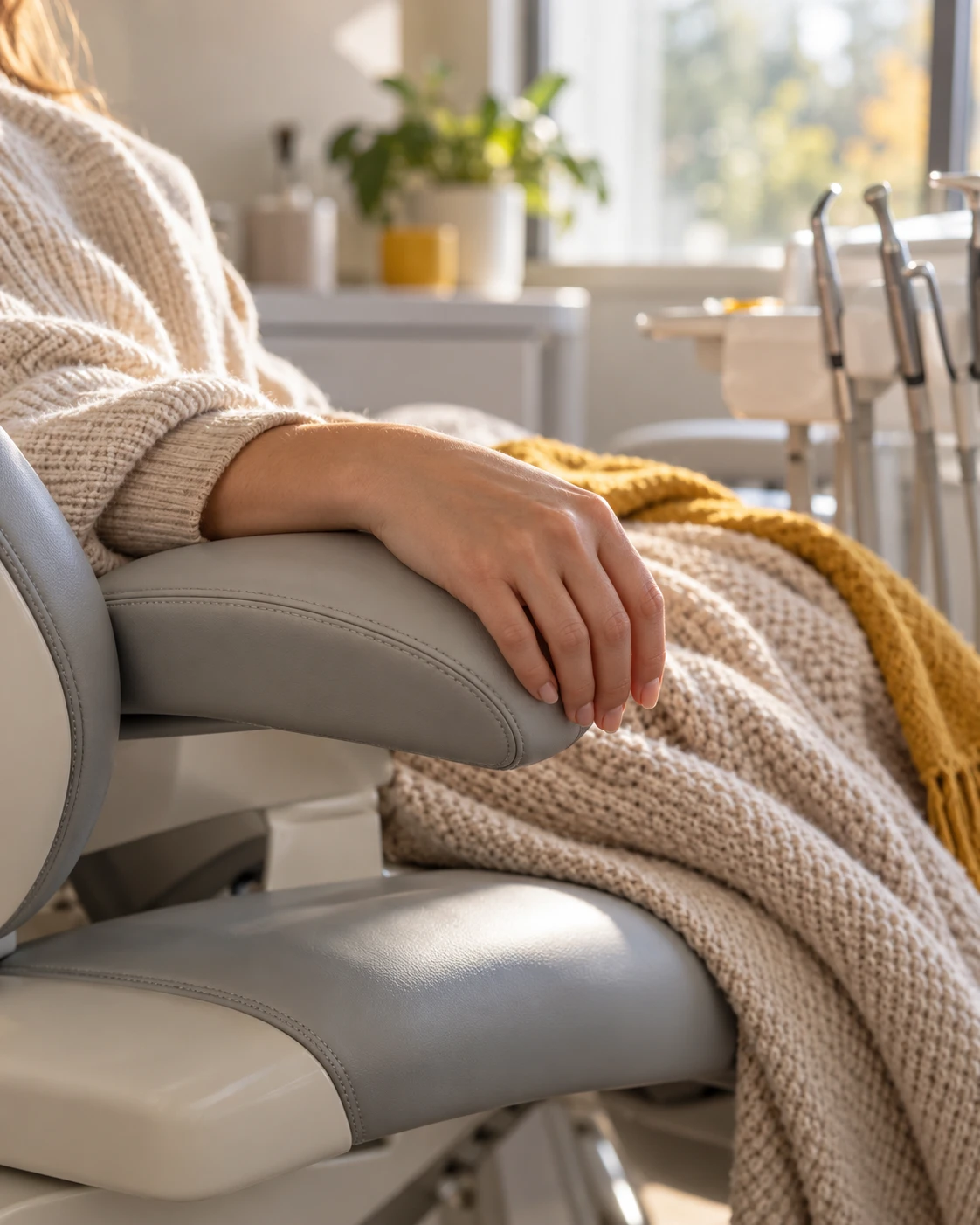 Relaxed patient resting in a dental chair with a soft blanket